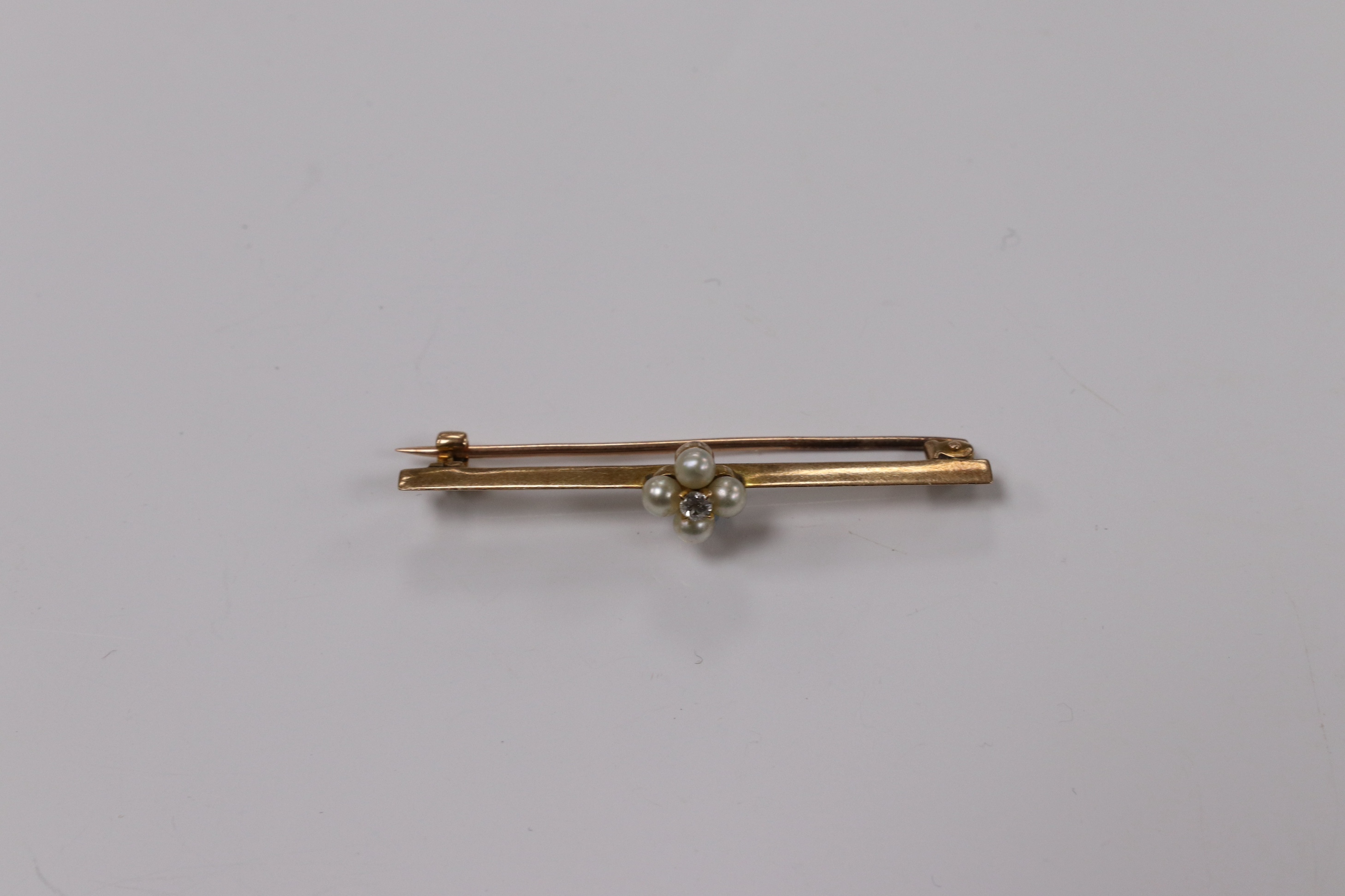 A yellow metal, diamond and seed pearl cluster set bar brooch, 44mm, gross weight 2.5 grams. Condition - fair to good